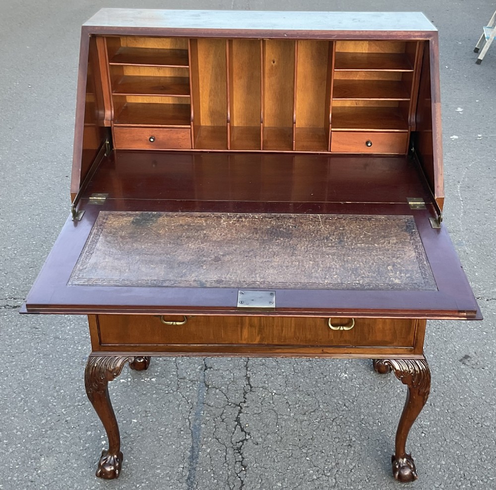A Chippendale style mahogany writing bureau featuring a angled slant-front lid above two drawers, raised on carved cabriole legs with ball-and-claw feet. View VII