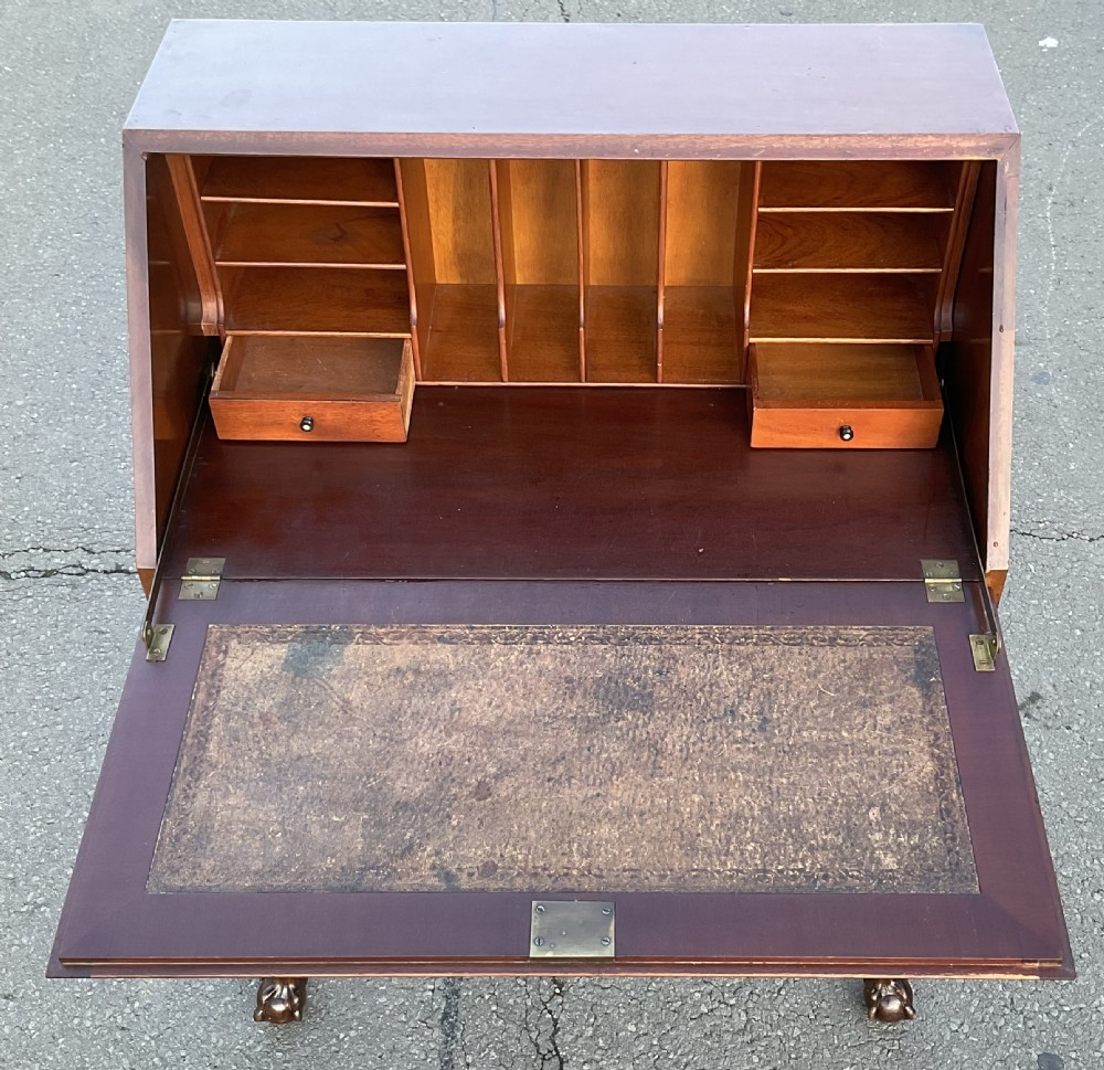 A Chippendale style mahogany writing bureau featuring a angled slant-front lid above two drawers, raised on carved cabriole legs with ball-and-claw feet. View XI