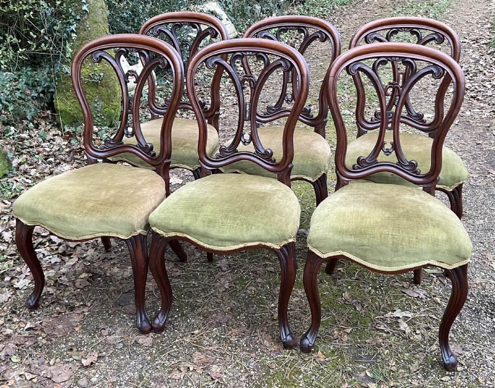 A set of six Victorian mahogany dining chairs featuring carved balloon back frames, cabriole front legs, and green velvet upholstered seats. View II
