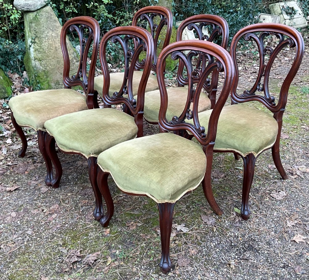A set of six Victorian mahogany dining chairs featuring carved balloon back frames, cabriole front legs, and green velvet upholstered seats. View III