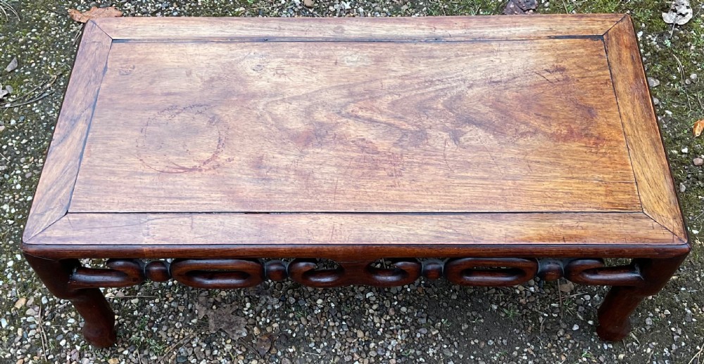 A low rectangular oriental hardwood coffee table featuring an intricately carved openwork apron and curved legs. View III