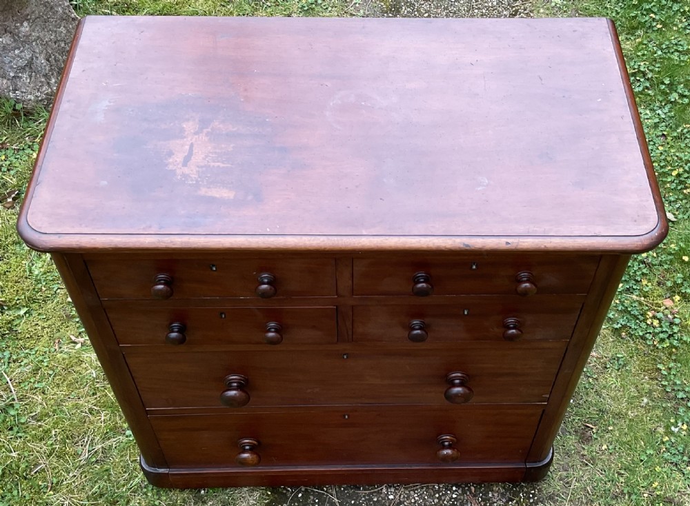 A Victorian mahogany chest of drawers featuring four short upper drawers above two long lower drawers with turned wooden knobs and a solid plinth base. View IV