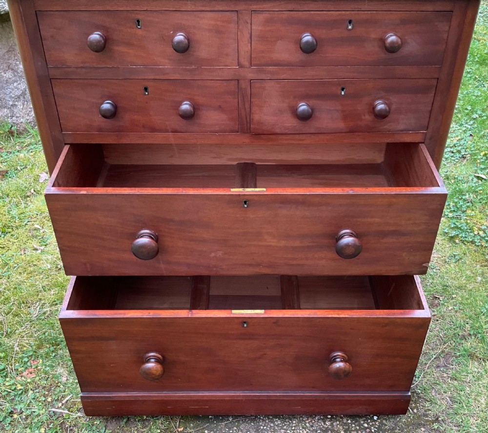 A Victorian mahogany chest of drawers featuring four short upper drawers above two long lower drawers with turned wooden knobs and a solid plinth base. View X