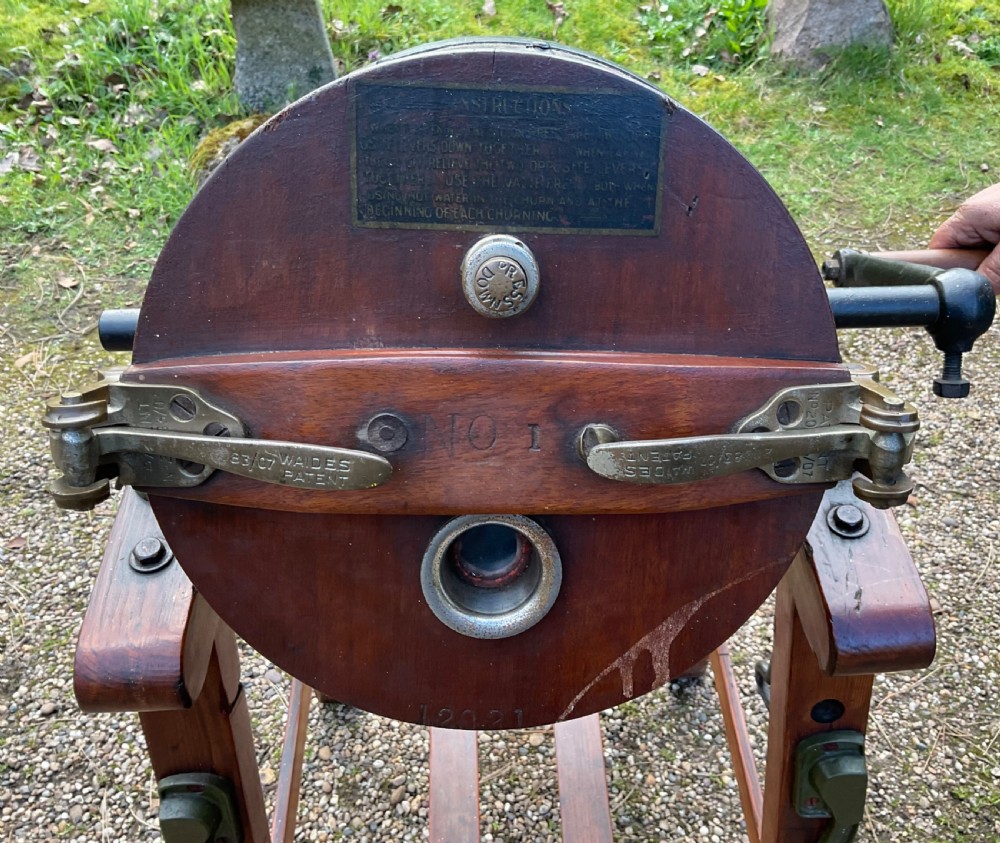 An Edwardian oak barrel butter churn mounted at an angle on a wooden four-legged stand with a side crank handle and metal hoops. View VII