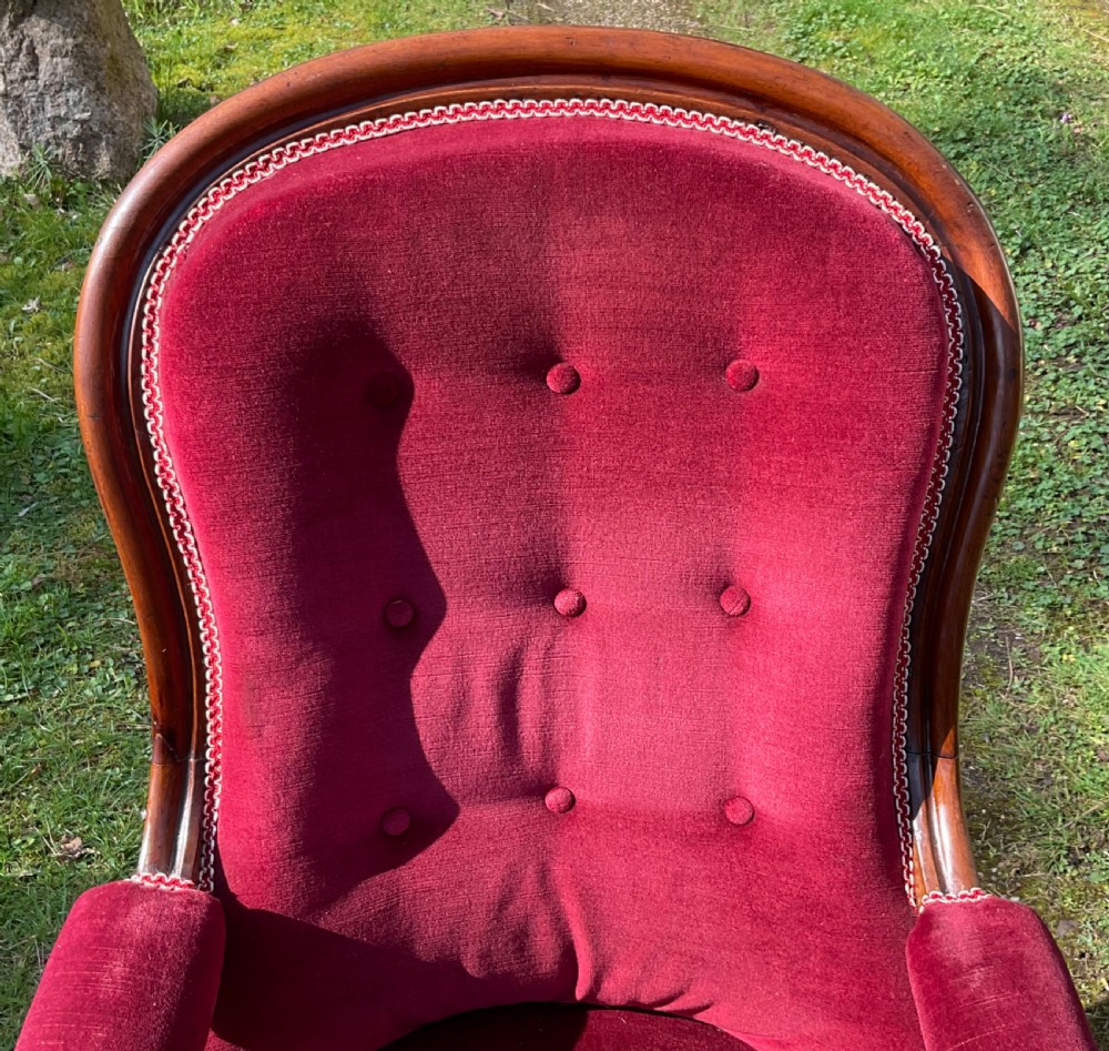 A William IV mahogany armchair upholstered in crimson red velvet with button-backed cushioning and turned front legs on castors. View III