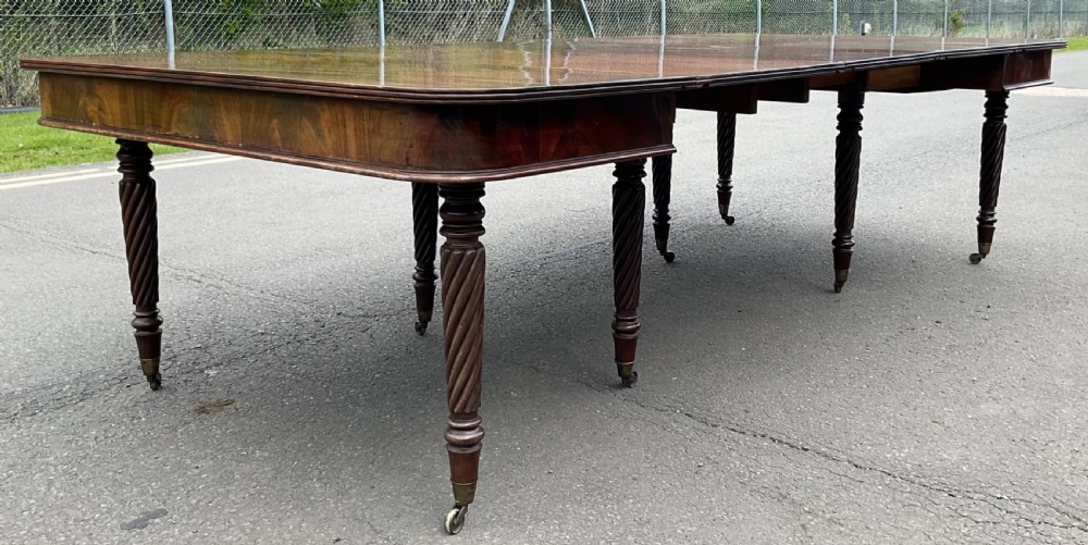 A large Regency mahogany extending dining table featuring spiral-turned legs fitted with brass castors. View III
