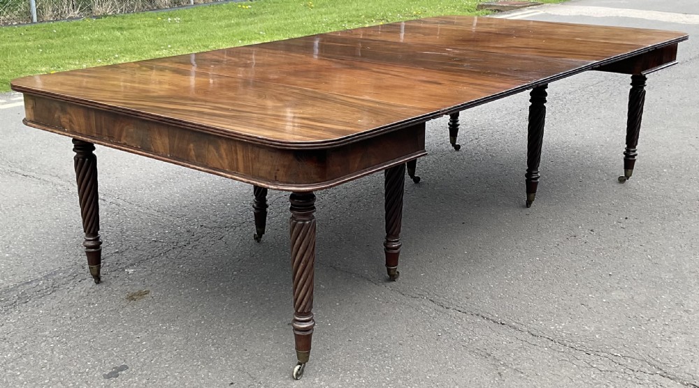 A large Regency mahogany extending dining table featuring spiral-turned legs fitted with brass castors. View IV