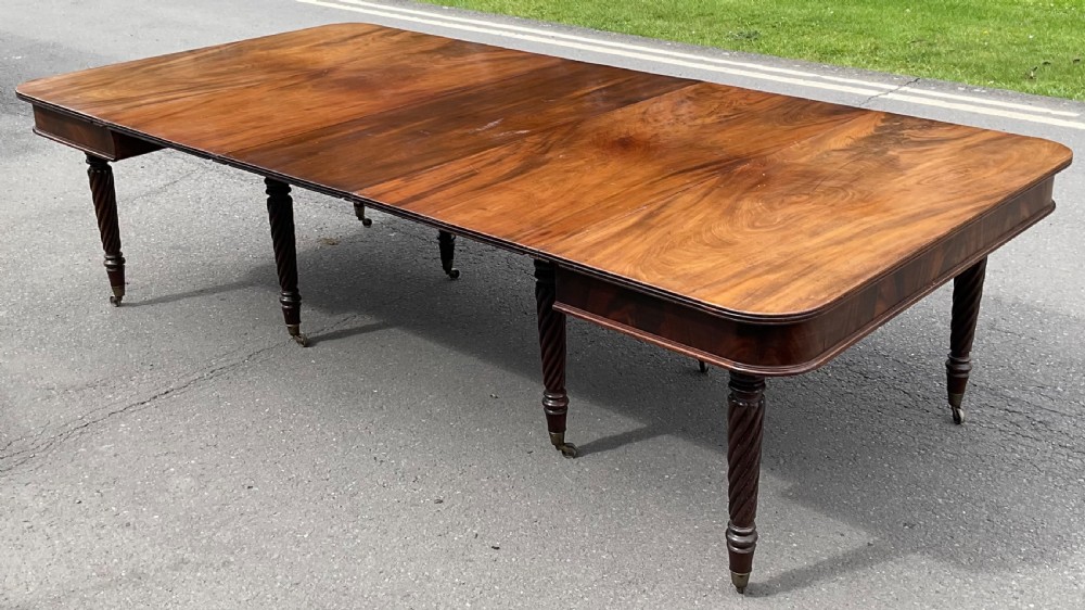 A large Regency mahogany extending dining table featuring spiral-turned legs fitted with brass castors. View VI