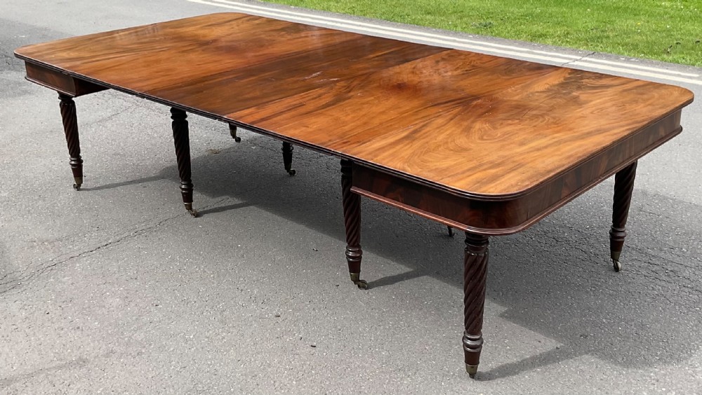 A large Regency mahogany extending dining table featuring spiral-turned legs fitted with brass castors. View VII