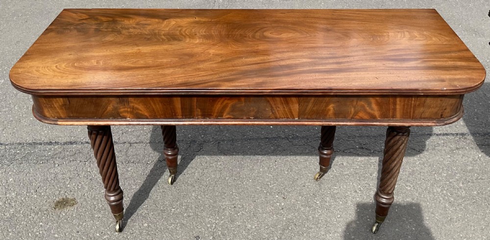 A large Regency mahogany extending dining table featuring spiral-turned legs fitted with brass castors. View IX