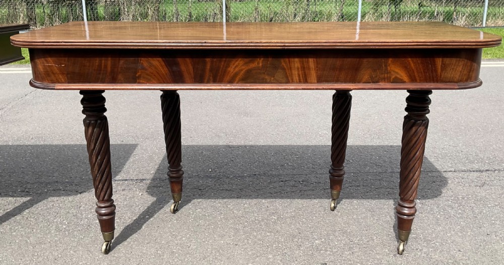 A large Regency mahogany extending dining table featuring spiral-turned legs fitted with brass castors. View XIII