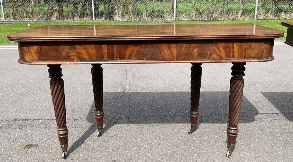 A large Regency mahogany extending dining table featuring spiral-turned legs fitted with brass castors. View XV