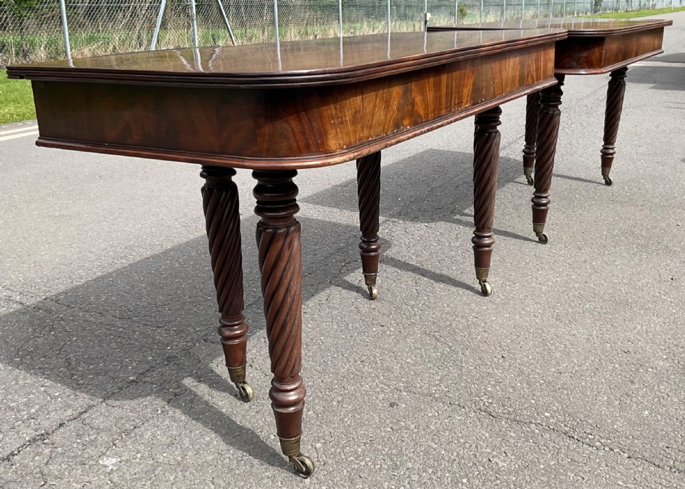 A large Regency mahogany extending dining table featuring spiral-turned legs fitted with brass castors. View XVII
