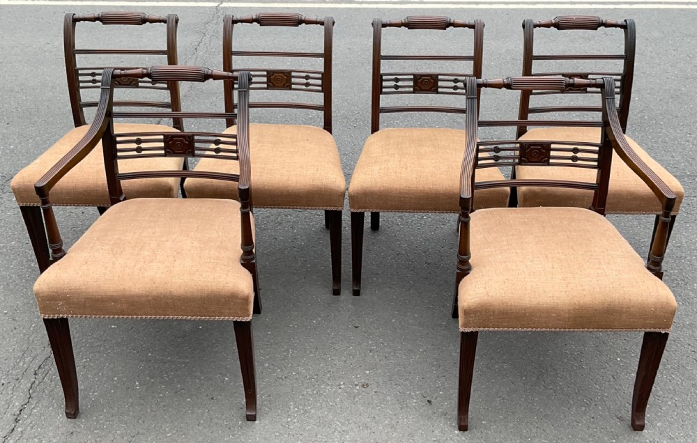 Set of six dark mahogany Georgian dining chairs featuring reeded frames, carved bar backs, and beige fabric seats. View II