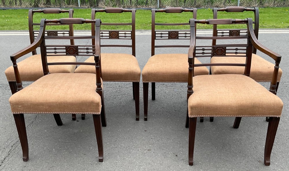 Set of six dark mahogany Georgian dining chairs featuring reeded frames, carved bar backs, and beige fabric seats. View III