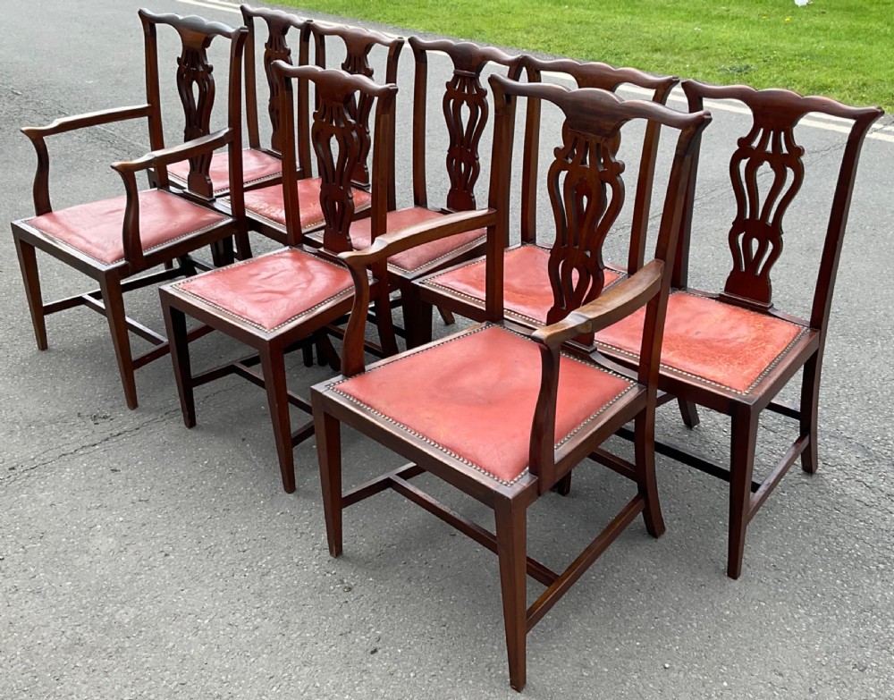 A set of eight Edwardian mahogany dining chairs featuring pierced back splats, square legs with stretchers, and red leather seats detailed with brass studding. View V