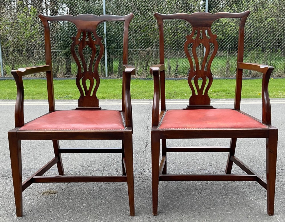 A set of eight Edwardian mahogany dining chairs featuring pierced back splats, square legs with stretchers, and red leather seats detailed with brass studding. View VII