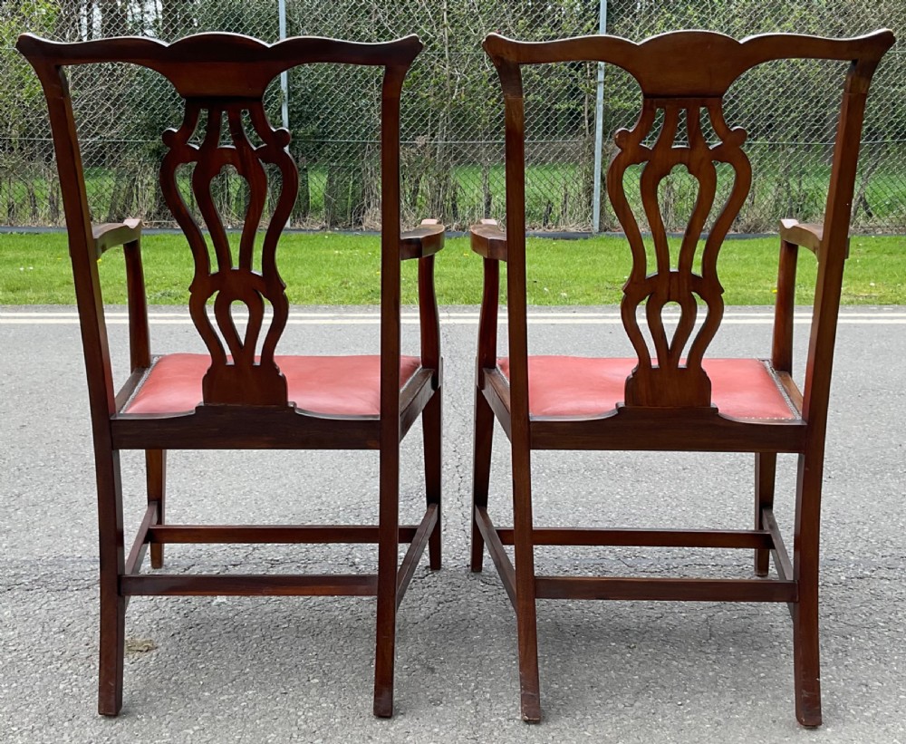 A set of eight Edwardian mahogany dining chairs featuring pierced back splats, square legs with stretchers, and red leather seats detailed with brass studding. View VIII