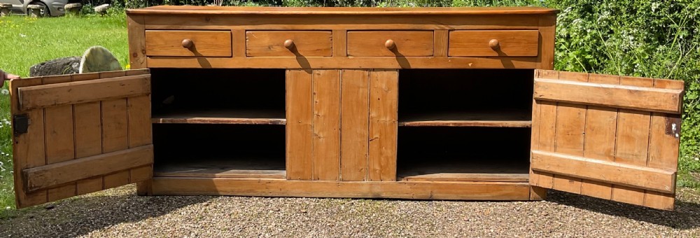 A long Victorian pine sideboard featuring four upper drawers above plank-fronted cupboard doors with turned wooden knobs. View VIII