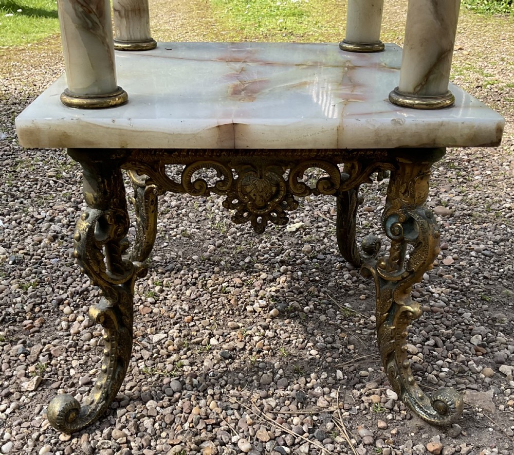 A two-tier square plant stand constructed from cream veined onyx with four cylindrical onyx columns and ornate cast brass feet and mounts. View IX