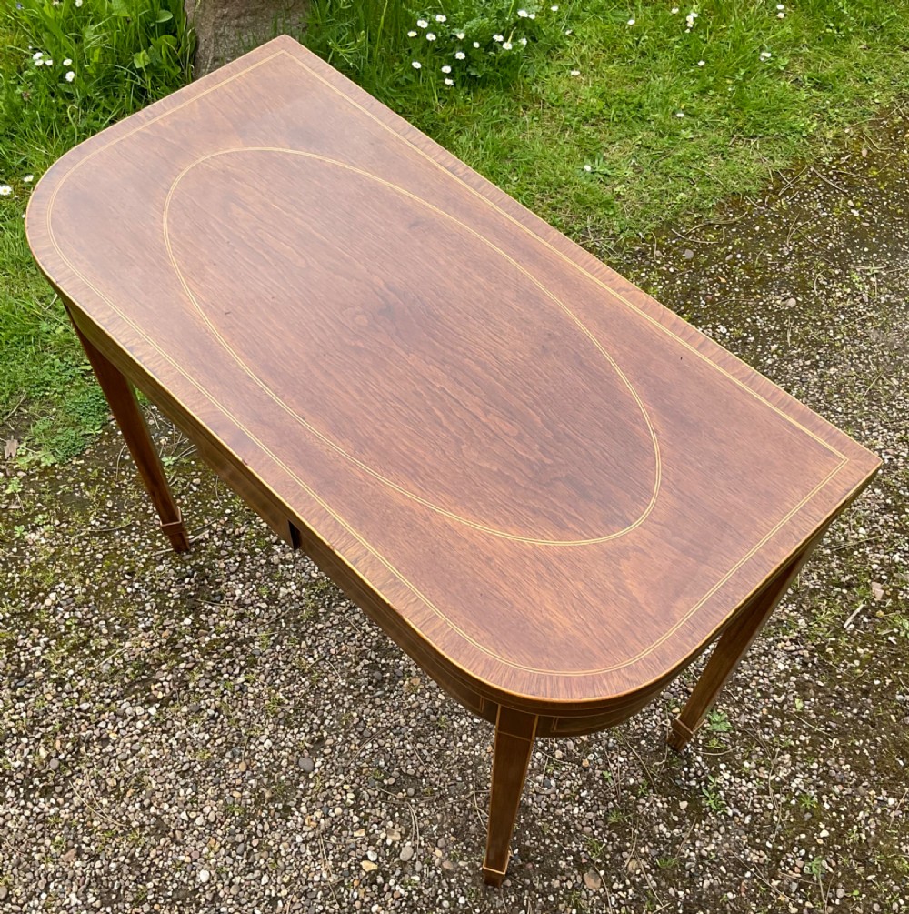 A Georgian inlaid mahogany foldover tea table featuring a rounded rectangular top, linear boxwood stringing, and square tapered legs. View III