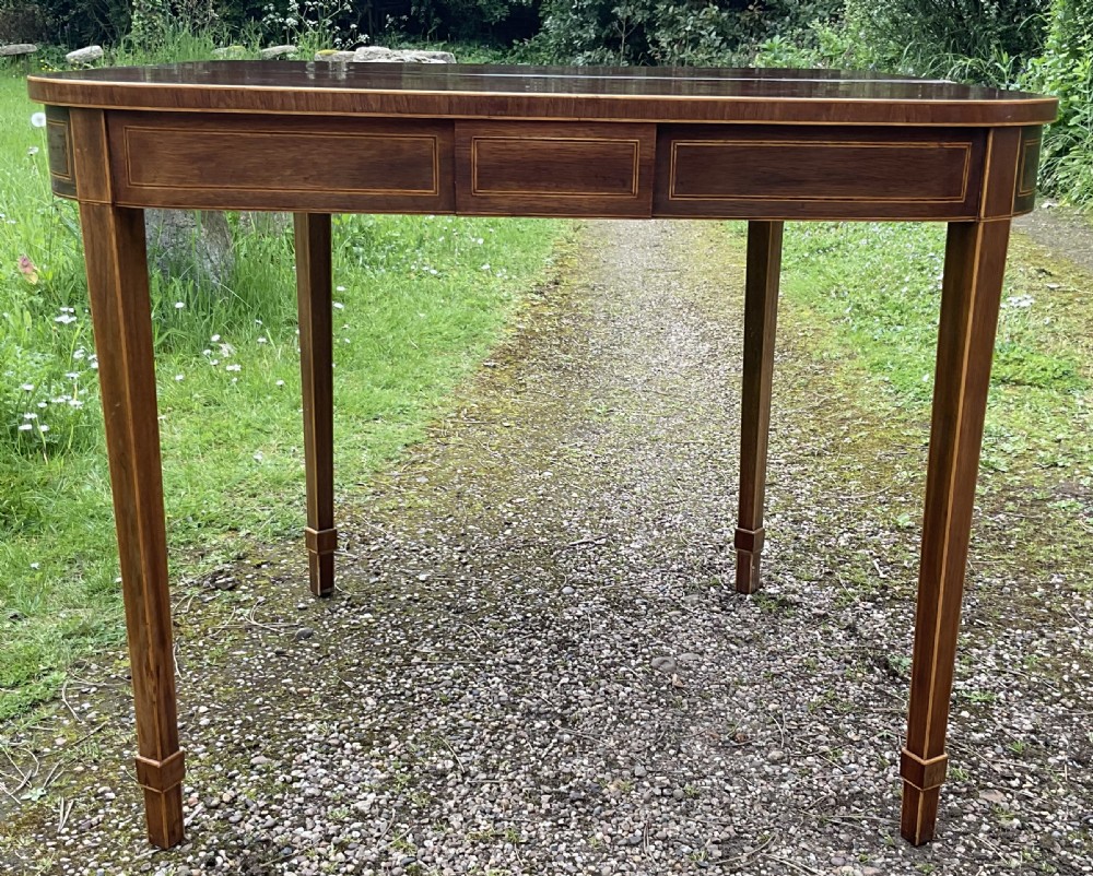 A Georgian inlaid mahogany foldover tea table featuring a rounded rectangular top, linear boxwood stringing, and square tapered legs. View VIII