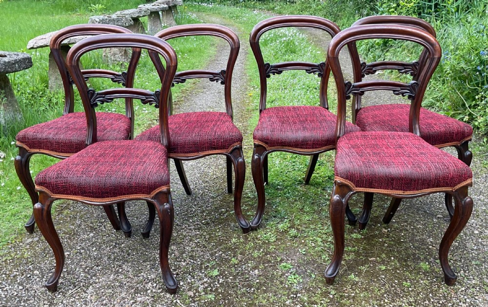 Set of six Victorian rosewood balloon back dining chairs featuring carved mid-rails, cabriole front legs, and red textured upholstered seats. View III