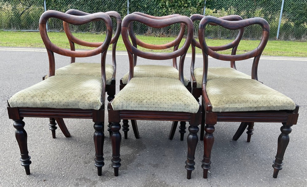 A set of six Victorian rosewood balloon back dining chairs with green velvet upholstered seats and turned front legs. View II