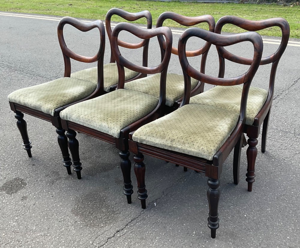 A set of six Victorian rosewood balloon back dining chairs with green velvet upholstered seats and turned front legs. View VI