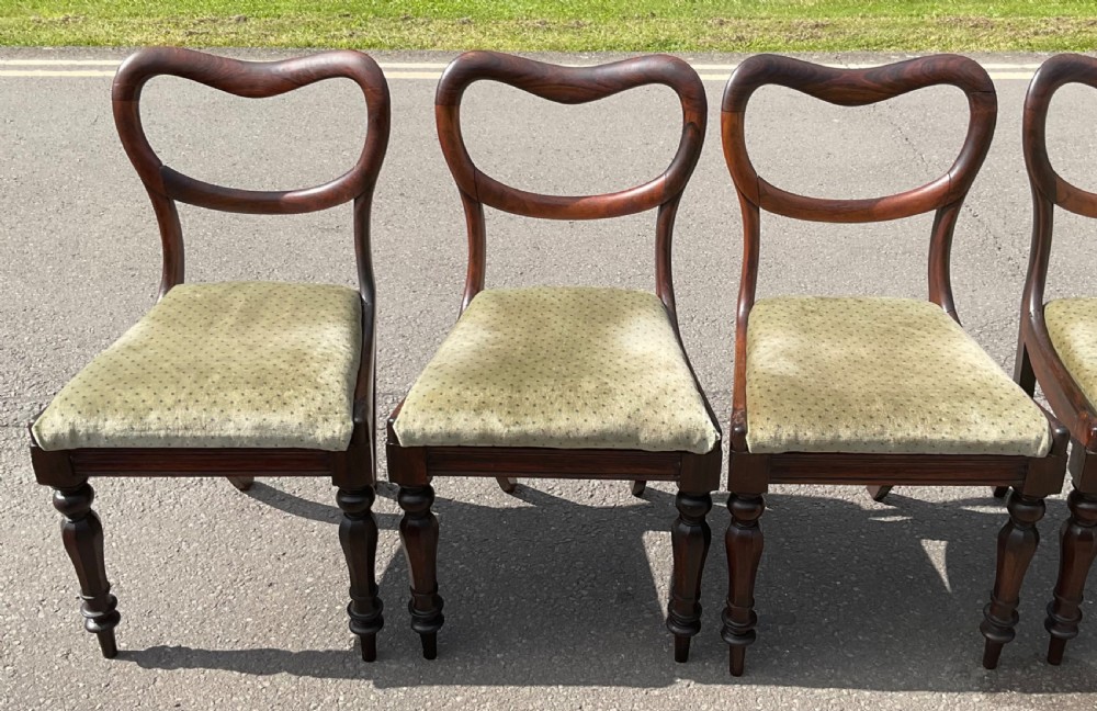 A set of six Victorian rosewood balloon back dining chairs with green velvet upholstered seats and turned front legs. View VIII