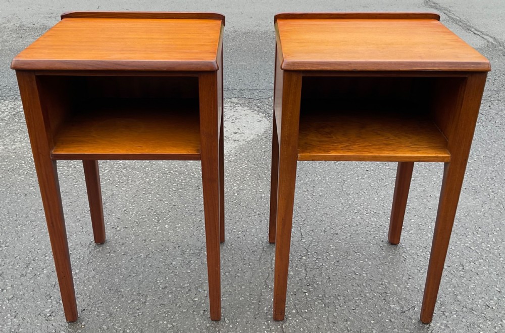 A pair of warm brown mahogany Art Deco lamp tables featuring open storage cubbies, raised gallery edges, and slender tapered legs.