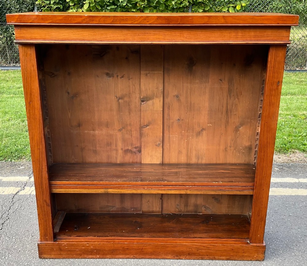 A low Victorian open mahogany bookcase featuring adjustable timber shelves and a plinth base.