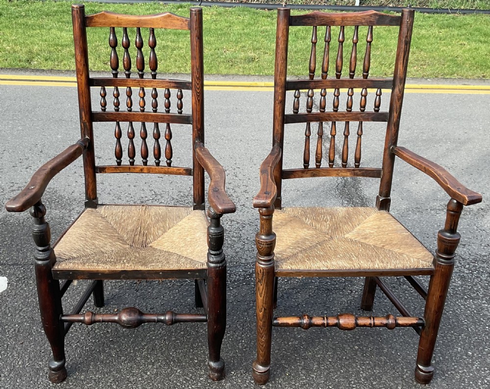 A set of eight Victorian dark elm dining chairs featuring turned spindle backs, side armrests on carvers, and woven rush seats. View VII