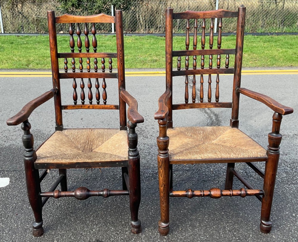 A set of eight Victorian dark elm dining chairs featuring turned spindle backs, side armrests on carvers, and woven rush seats. View VIII