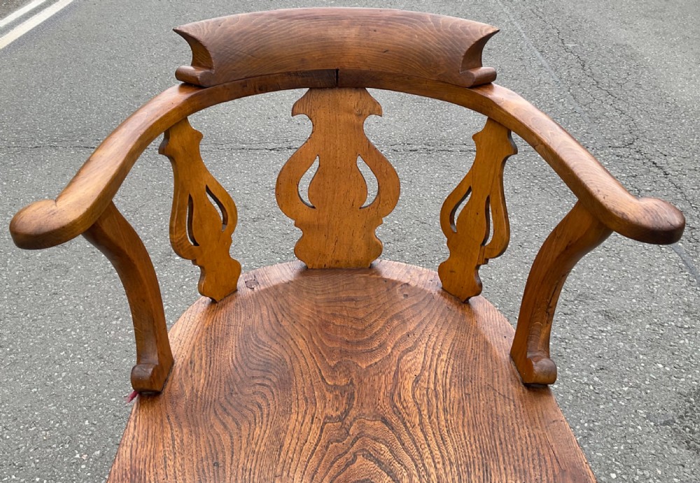 A Victorian elm captains armchair featuring a horseshoe backrest, carved vasiform splats, a shaped saddle seat, and turned legs with stretchers. View II