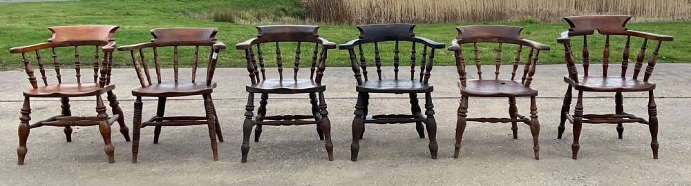 A set of six Victorian smokers bow armchairs with turned spindles, contoured saddle seats, and H-stretchers.