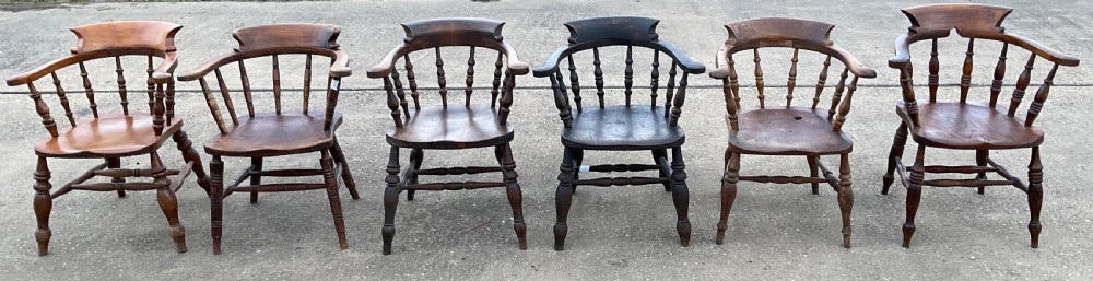 A set of six Victorian smokers bow armchairs with turned spindles, contoured saddle seats, and H-stretchers. View V