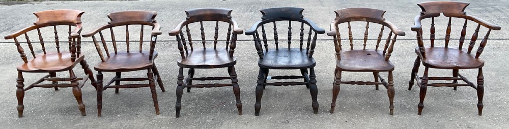 A set of six Victorian smokers bow armchairs with turned spindles, contoured saddle seats, and H-stretchers. View VI