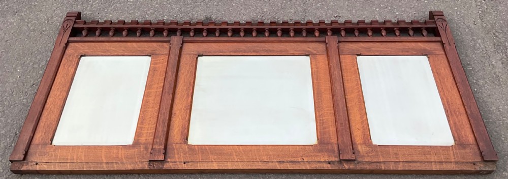 A large Victorian Gothic quarter-sawn oak overmantel mirror featuring three mirror panels and a decorative spindle gallery along the top rail. View II