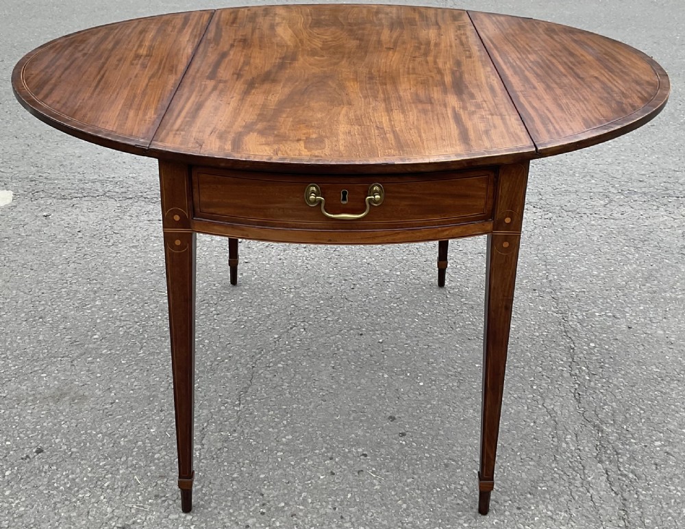 A Georgian mahogany oval drop-leaf Pembroke table featuring line inlay, a front drawer with a brass handle, and tapered square legs. View V