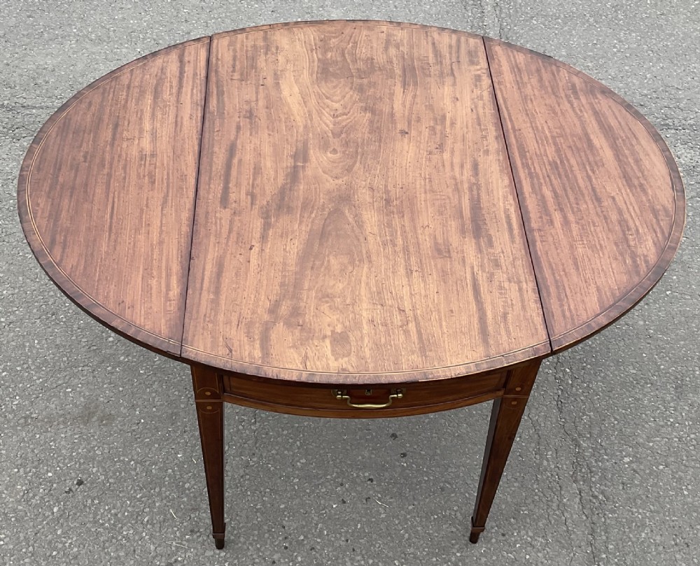 A Georgian mahogany oval drop-leaf Pembroke table featuring line inlay, a front drawer with a brass handle, and tapered square legs. View VII