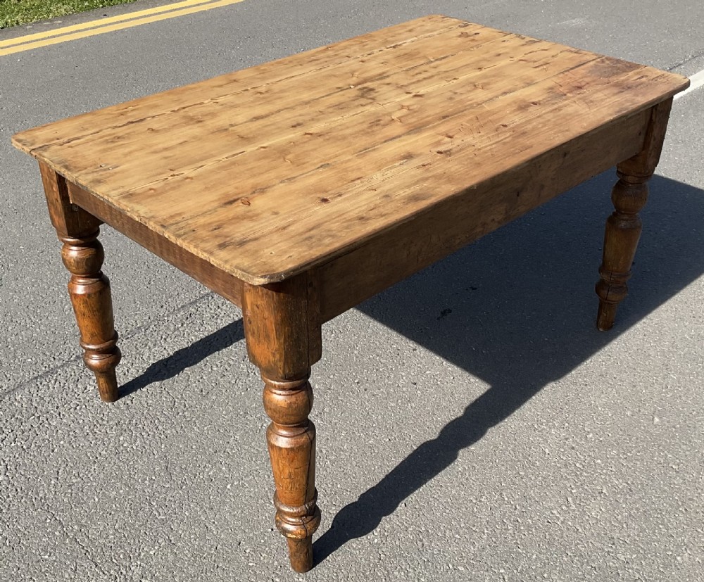 A rectangular Victorian pine kitchen table featuring a planked wood top and four turned wooden legs. View III