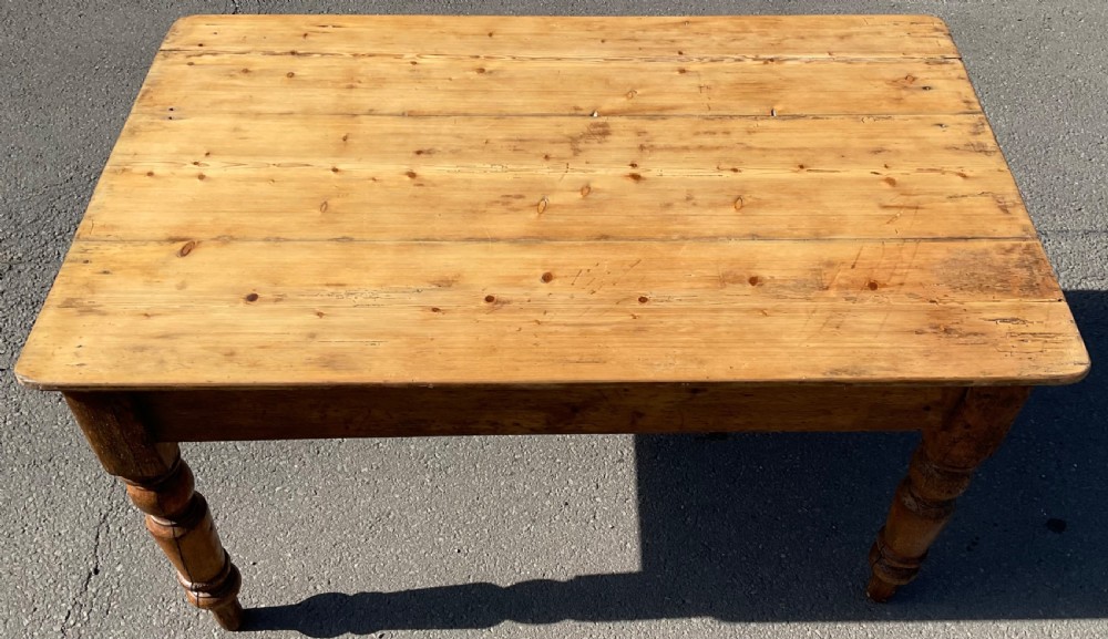A rectangular Victorian pine kitchen table featuring a planked wood top and four turned wooden legs. View IV