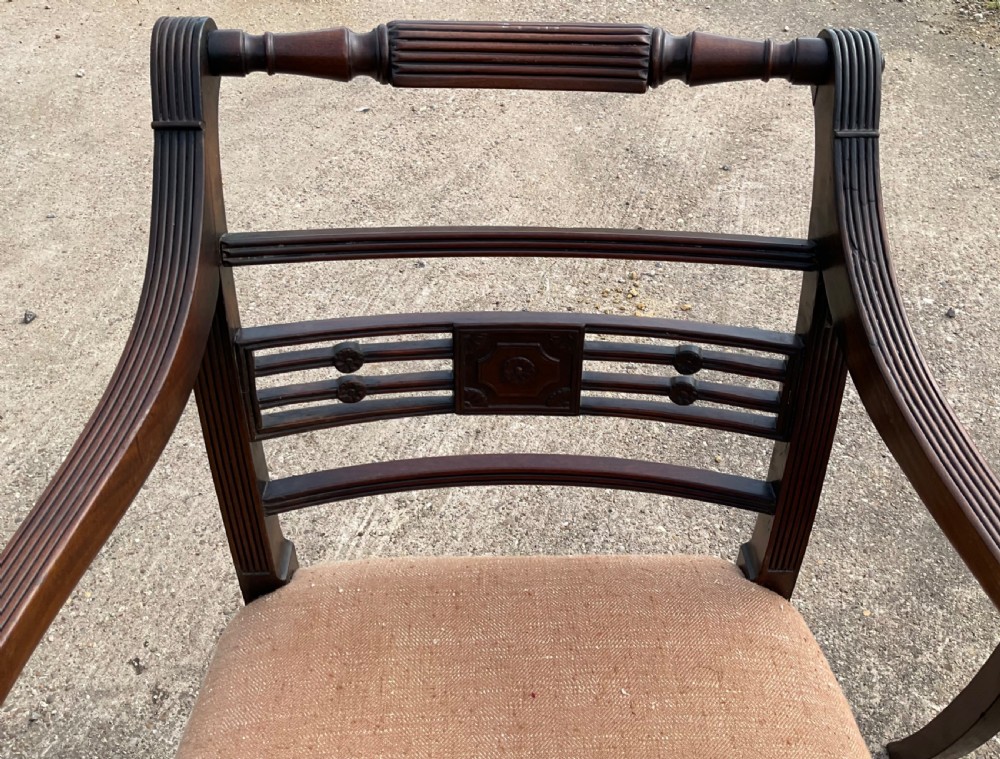 A pair of antique Georgian mahogany carver armchairs with reeded front legs, carved horizontal back splats, and neutral fabric seats. View III