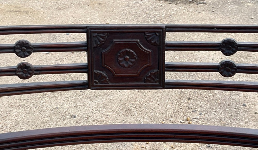 A pair of antique Georgian mahogany carver armchairs with reeded front legs, carved horizontal back splats, and neutral fabric seats. View V