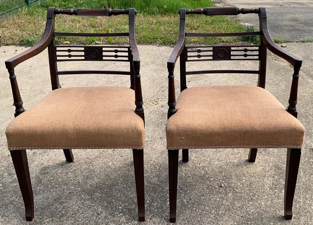 A pair of antique Georgian mahogany carver armchairs with reeded front legs, carved horizontal back splats, and neutral fabric seats. View VII