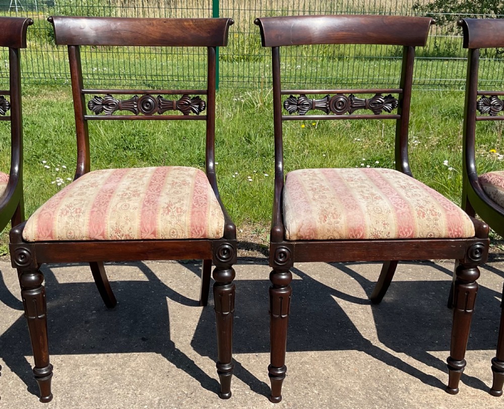 A set of six dark rosewood Regency dining chairs featuring carved bar back rails, turned front legs, and striped upholstered seats. View III