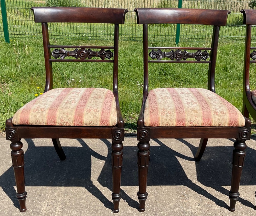 A set of six dark rosewood Regency dining chairs featuring carved bar back rails, turned front legs, and striped upholstered seats. View IV