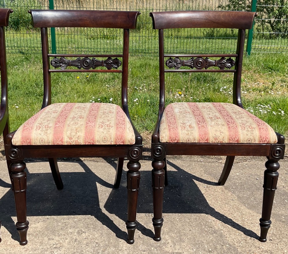 A set of six dark rosewood Regency dining chairs featuring carved bar back rails, turned front legs, and striped upholstered seats. View VI