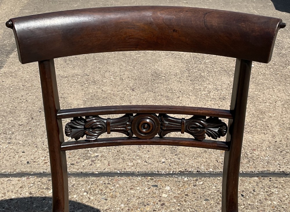 A set of six dark rosewood Regency dining chairs featuring carved bar back rails, turned front legs, and striped upholstered seats. View XI